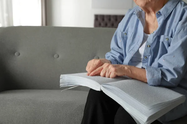 Ciego persona mayor lectura libro escrito en braille en el sofá en el interior, primer plano. Espacio para texto —  Fotos de Stock