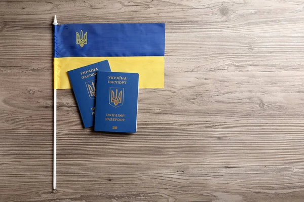 Украинские загранпаспорта и государственный флаг на деревянном фоне, квартира лежала с пространством для текста. Международные отношения — стоковое фото