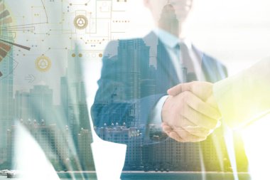 İşadamları şehir manzarasına karşı el sıkışıyor, yakın çekim. Çift pozlama