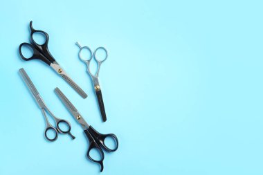 Düz renk arka planda metin için makas ve boşluk ile kompozisyon yatıyordu. Kuaför aletleri