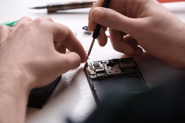 Teknisyen masada cep telefonu tamir, closeup. Cihaz onarım hizmeti