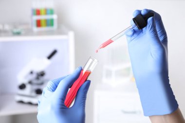 Kimya laboratuvarında test tüpüne damlama numunesi asistanı, closeup
