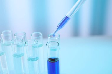 Dripping sample into test tube in chemistry laboratory, closeup