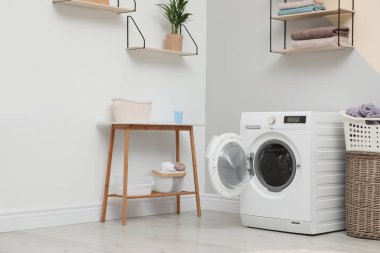Çamaşır odasının içindeki modern çamaşır makinesi.