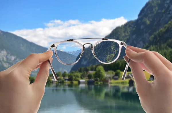 Kvinna tittar genom glasögon, närbild. Förbättring av synen efter besökande ögonläkare — Stockfoto