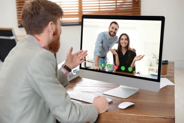 Homem ter vídeo chat com colegas à mesa no escritório — Fotografia de Stock