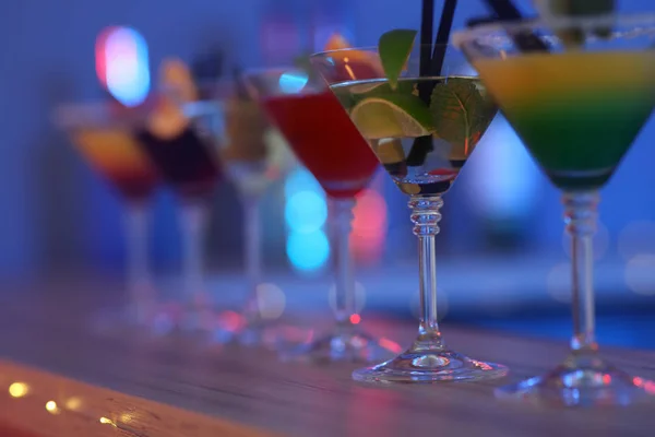 Verschillende Martini cocktails op tafel tegen onscherpe achtergrond, close-up met ruimte voor tekst — Stockfoto