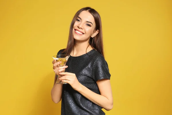 Piękna młoda kobieta z kieliszką koktajl Martini na kolorowym tle — Zdjęcie stockowe