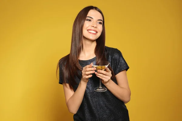 Piękna młoda kobieta z kieliszką koktajl Martini na kolorowym tle — Zdjęcie stockowe