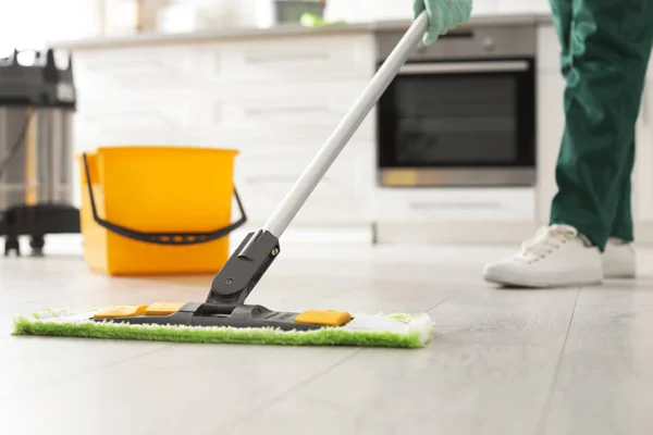 Professional janitor cleaning floor with mop in kitchen, closeup. Space for text — Stock Photo, Image