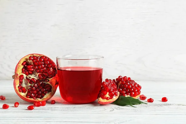 Vaso de jugo de granada y frutas frescas sobre mesa de madera, espacio para texto —  Fotos de Stock