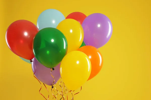 Bando de balões brilhantes sobre fundo de cor, espaço para texto. Tempo de celebração — Fotografia de Stock