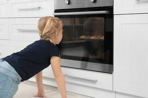 Menina esperando pela preparação de biscoitos no forno em casa — Fotografia de Stock