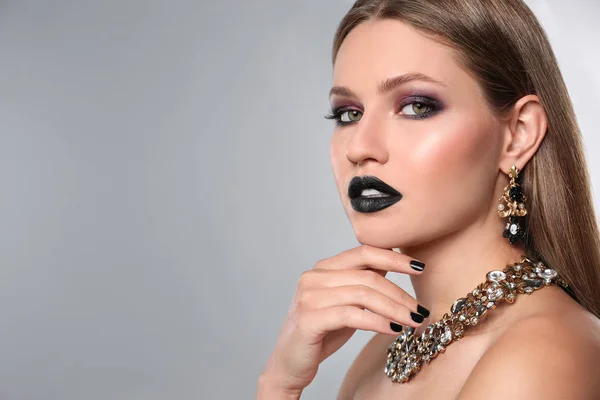 Schöne Frau mit stylischem Nagellack auf grauem Hintergrund, Platz für Text — Stockfoto