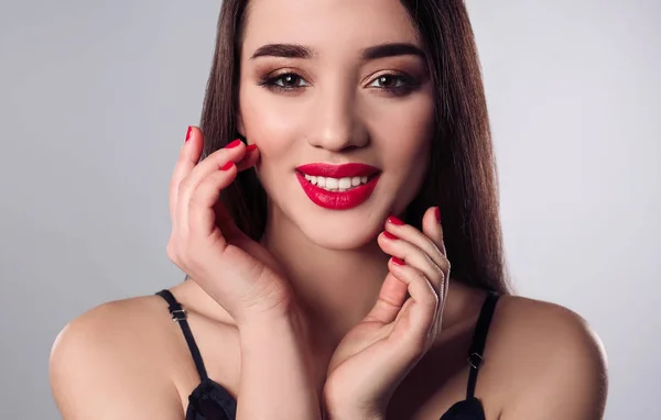 Hermosa mujer con esmalte de uñas con estilo sobre fondo gris —  Fotos de Stock