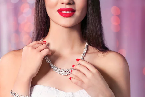 Hermosa mujer con joyas con estilo contra las luces borrosas, primer plano — Foto de Stock