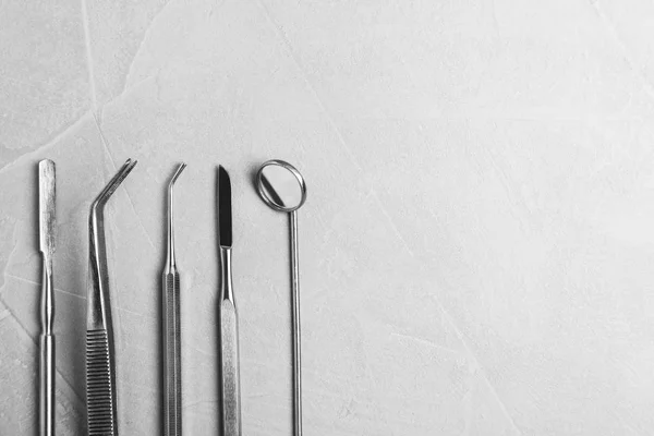 Ferramentas odontológicas profissionais em fundo cinza, flat lay. Espaço para texto — Fotografia de Stock