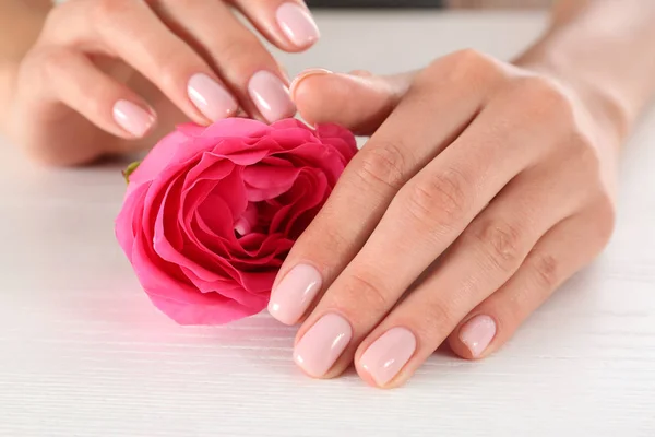 Vista de cerca de la mujer con rosa en la mesa de madera blanca. Tratamiento de spa — Foto de Stock