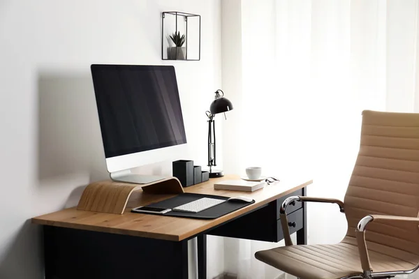 テーブルの上に現代のコンピュータが付いているスタイリッシュな職場のインテリア。デザインモックアップ — ストック写真