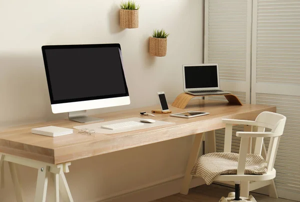 Elegante interior del lugar de trabajo con ordenador moderno en la mesa. Burla para el diseño — Foto de Stock