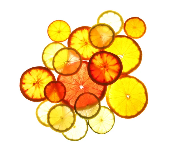 Illuminated slices of citrus fruits on white background, top view — Stock Photo, Image