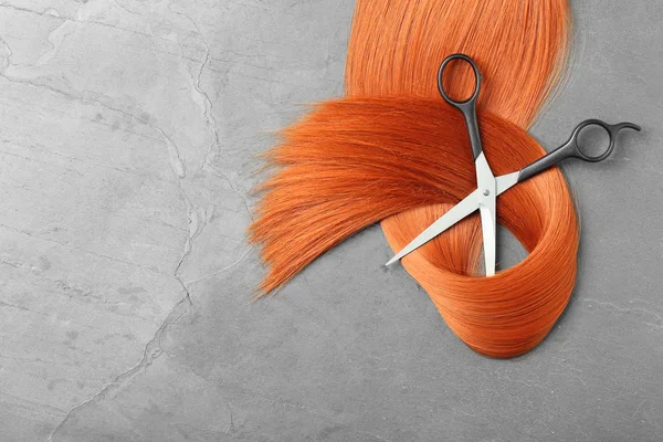 Composizione flat lay con capelli rossi, forbici e spazio per testo su fondo grigio. Servizio parrucchiere — Foto Stock