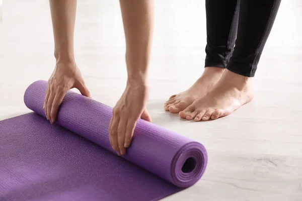 Tapis de yoga roulant femme sur le sol à l'intérieur, gros plan — Photo