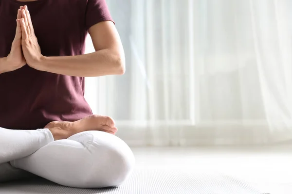 Mujer practicando yoga en el suelo en interiores, primer plano. Espacio para texto — Foto de Stock