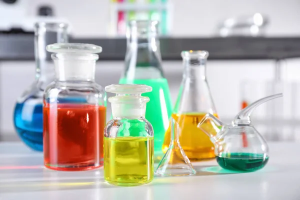 Διαφορετικά γυάλινα είδη με δείγματα στο τραπέζι στο εργαστήριο χημείας — Φωτογραφία Αρχείου