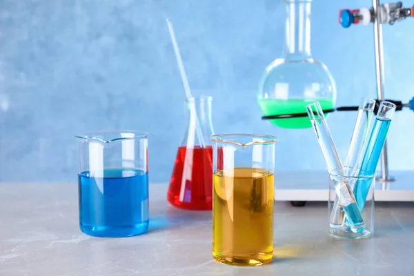 Διαφορετικά γυάλινα είδη με δείγματα στο τραπέζι στο εργαστήριο χημείας — Φωτογραφία Αρχείου