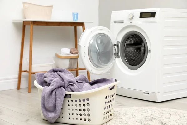 Cesta com lavandaria e máquina de lavar roupa dentro de casa — Fotografia de Stock