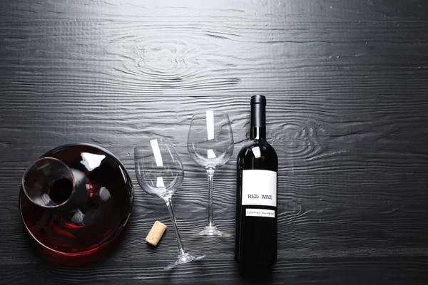 Καράφα, γυαλιά και μπουκάλι με κόκκινο κρασί σε ξύλινο φόντο, επίπεδη. Χώρος για κείμενο — Φωτογραφία Αρχείου