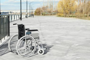 Güneşli bir günde setüzerinde boş tekerlekli sandalye. Metin için alan