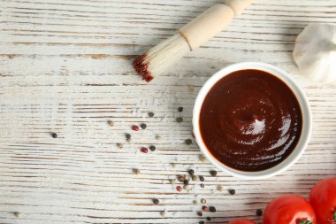 Beyaz ahşap masa üzerinde barbekü sosu ile Düz yatıyordu kompozisyon. Metin için alan