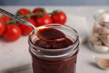 Kavanoz ve kaşık masada barbekü sosu ile, closeup