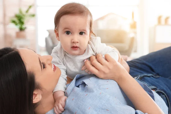 Feliz joven madre jugando con el bebé en el suelo en casa — Foto de Stock