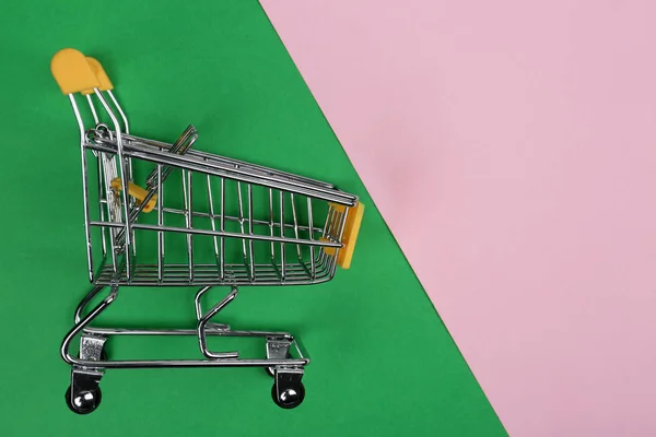 Empty shopping trolley on color background, top view. Space for text — Stock Photo, Image