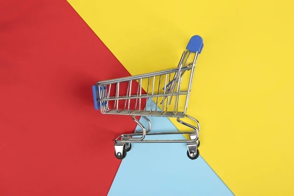 Empty shopping trolley on color background, top view — Stock Photo, Image