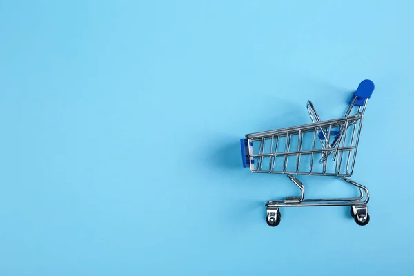 Empty shopping trolley on color background, top view. Space for text — Stock Photo, Image