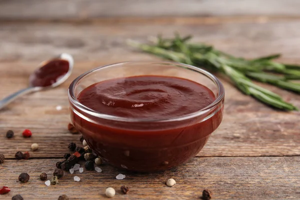 Komposition mit Schüssel Barbecue-Sauce auf Holztisch — Stockfoto