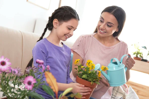 Mor och dotter vattning krukväxter hemma — Stockfoto