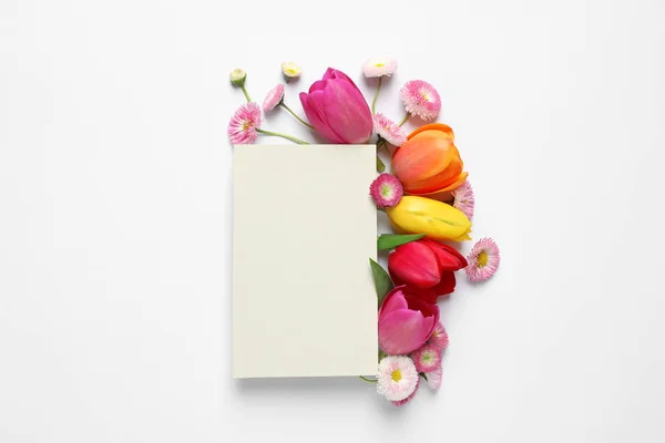 Beautiful composition with spring flowers and blank card on white background, top view. Space for text — Stock Photo, Image