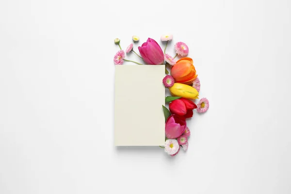 Beautiful composition with spring flowers and blank card on white background, top view. Space for text — Stock Photo, Image