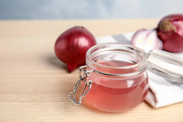 Vaso di vetro con sciroppo di cipolla e ingrediente fresco sul tavolo di legno. Spazio per testo — Foto Stock