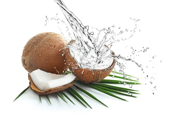 Heerlijke tropische kokosnoten en spattend water op witte achtergrond — Stockfoto