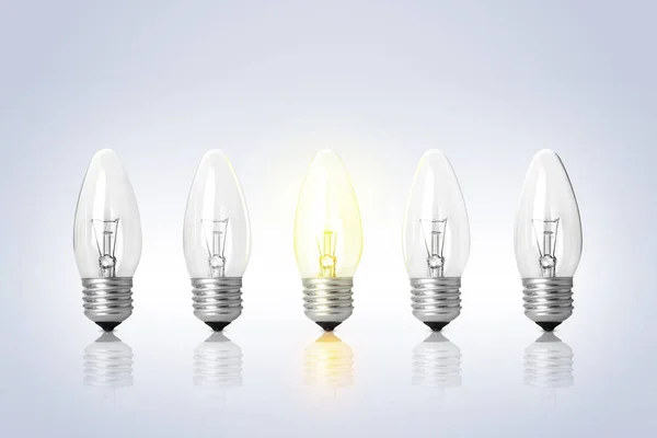 Many lamp bulbs on light background. Symbol of idea and solution