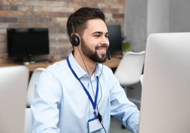 Ofis içinde çalışan kulaklıkla teknik destek operatörü