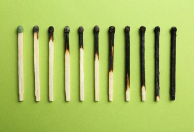 Yanmış kibrit satır ve renk arka plan üzerinde bütün bir, düz yatıyordu. İnsan yaşamı evreleri kavramı