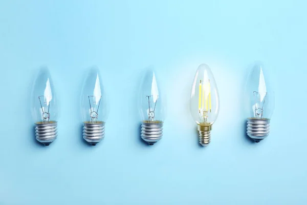 Muchas bombillas de lámpara en el fondo de color, vista superior. Símbolo de idea y solución — Foto de Stock