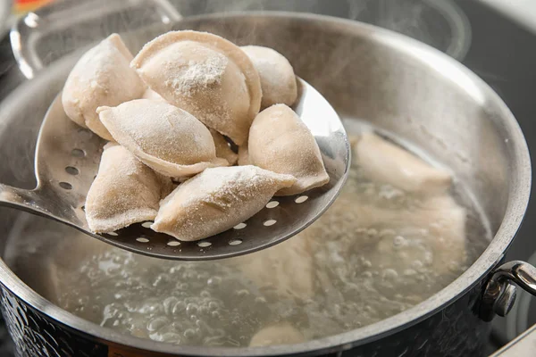 Närbild av dum Plings på skimmer över stek gryta med kokande vatten. Hus mans kost — Stockfoto